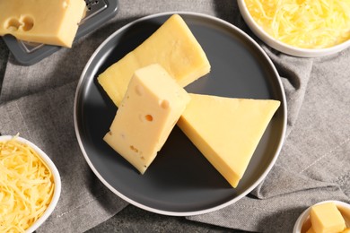 Grated and whole pieces of cheese on table, flat lay