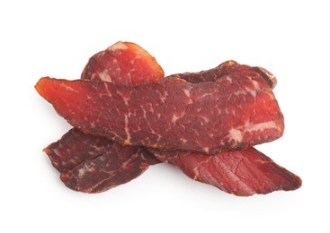 Photo of Pieces of delicious beef jerky on white background, top view