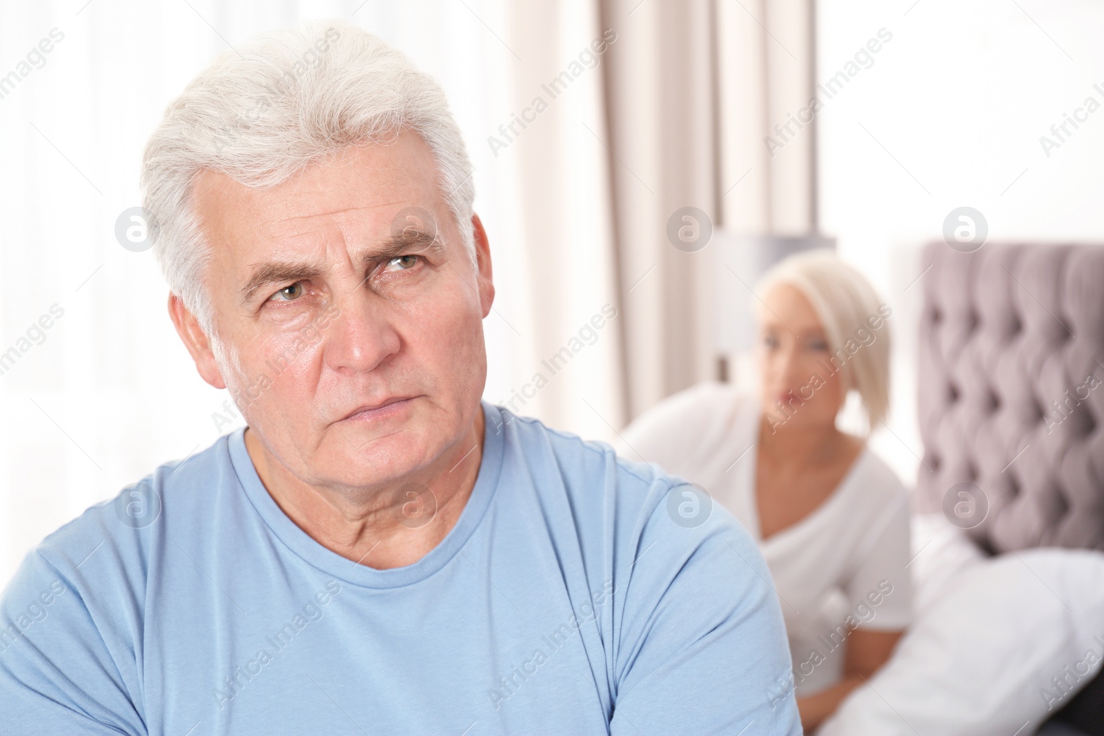 Photo of Senior man having conflict with his wife in bedroom. Relationship problems