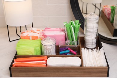 Photo of Wooden organizer with different feminine hygiene products on table