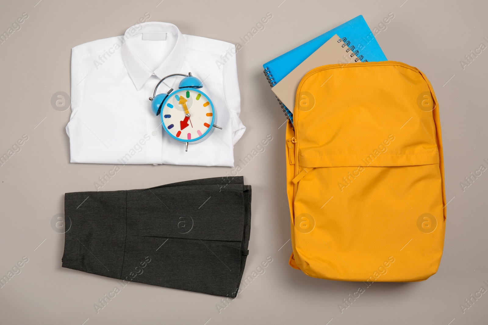 Photo of School uniform for girl and backpack on grey background, top view