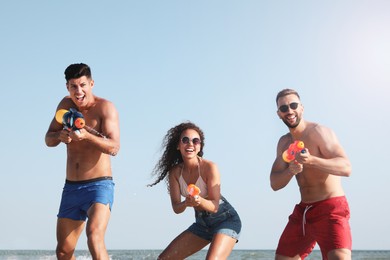 Photo of Friends with water guns having fun on beach