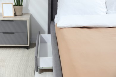 Storage drawer for bedding under modern bed in room