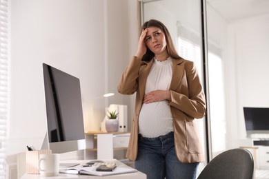 Photo of Tired pregnant woman working at home. Maternity leave