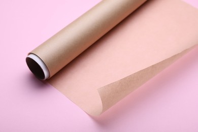 Photo of Roll of baking paper on pink background, closeup