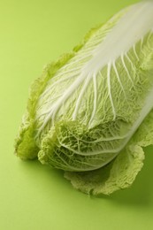 Photo of Fresh ripe Chinese cabbage on light green background, closeup