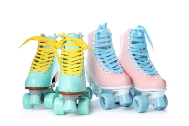 Pairs of bright stylish roller skates on white background