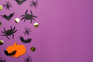 Photo of Flat lay composition with paper pumpkin, spiders and bats on purple background, space for text. Halloween celebration