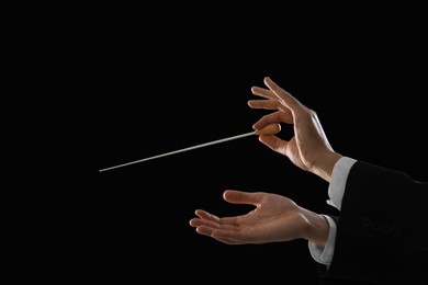 Photo of Professional conductor with baton on black background, closeup. Space for text