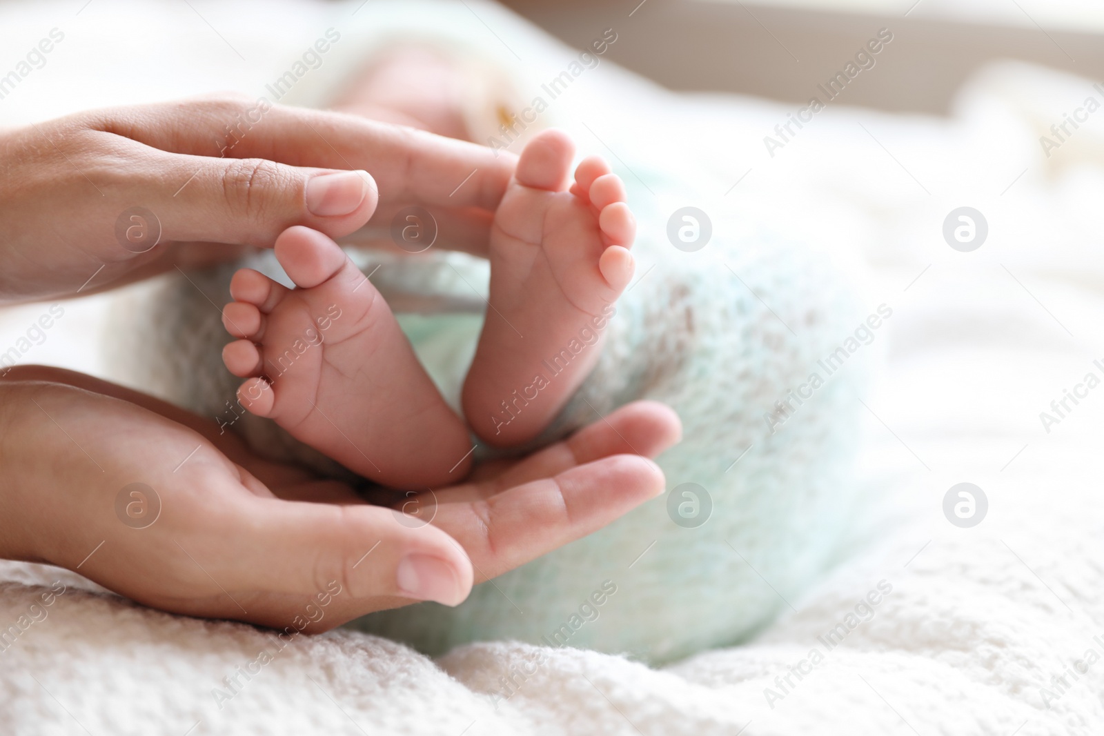 Photo of Mother and her newborn baby on white plaid, closeup