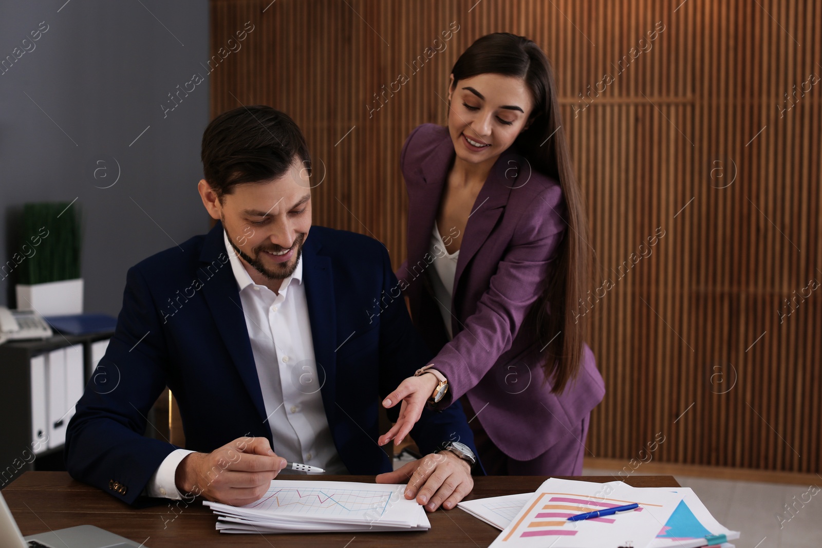 Photo of Office employees working with documents at table indoors