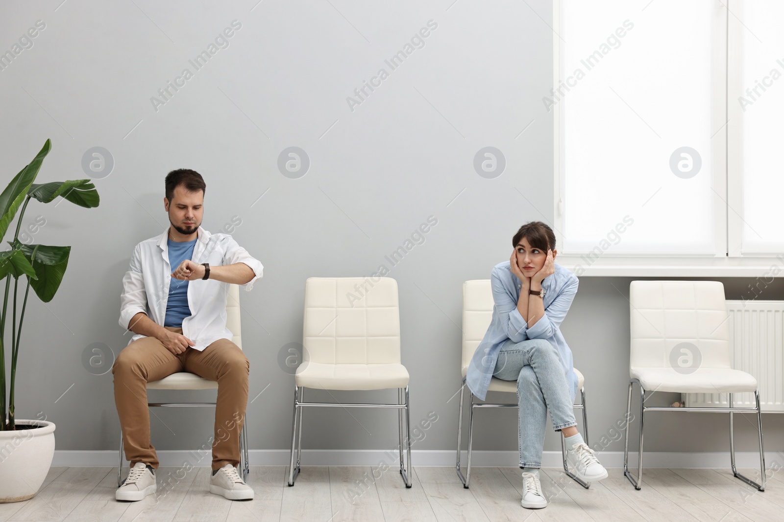 Photo of Man and woman waiting for appointment indoors