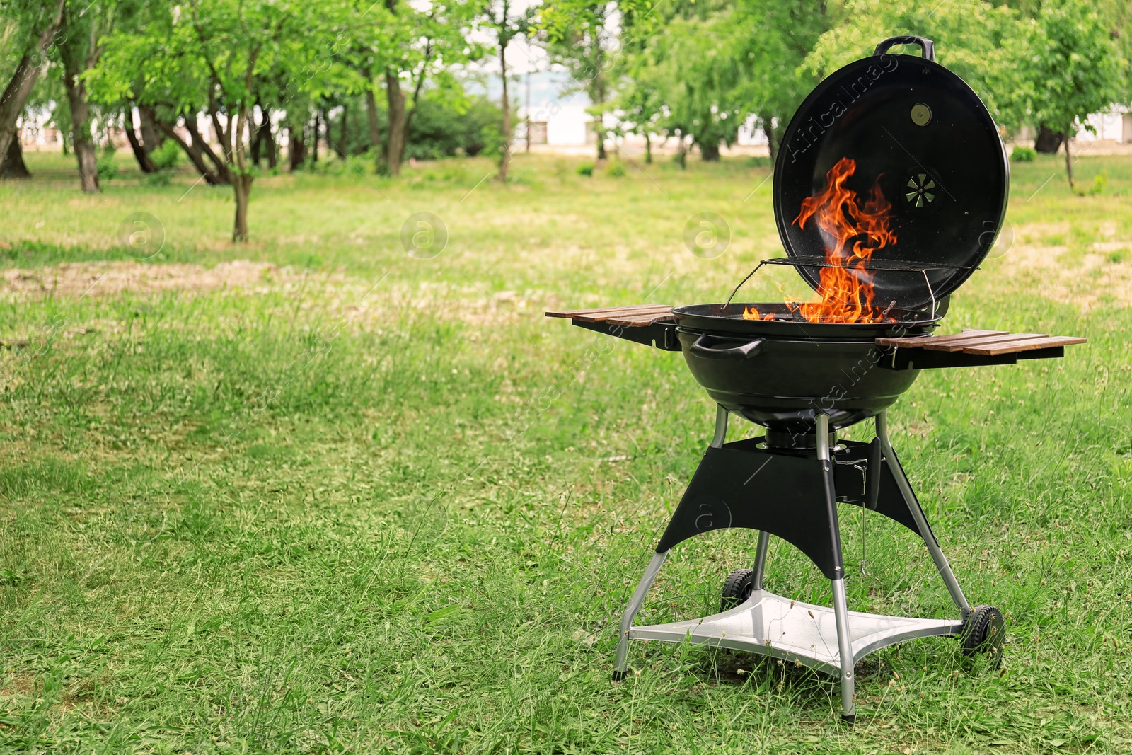 Photo of Modern barbecue grill with fire flames outdoors