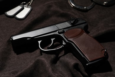 Photo of Standard handgun on dark fabric. Semi-automatic pistol