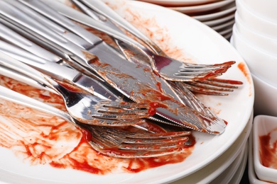 Photo of Stack of dirty dishes with cutlery, closeup