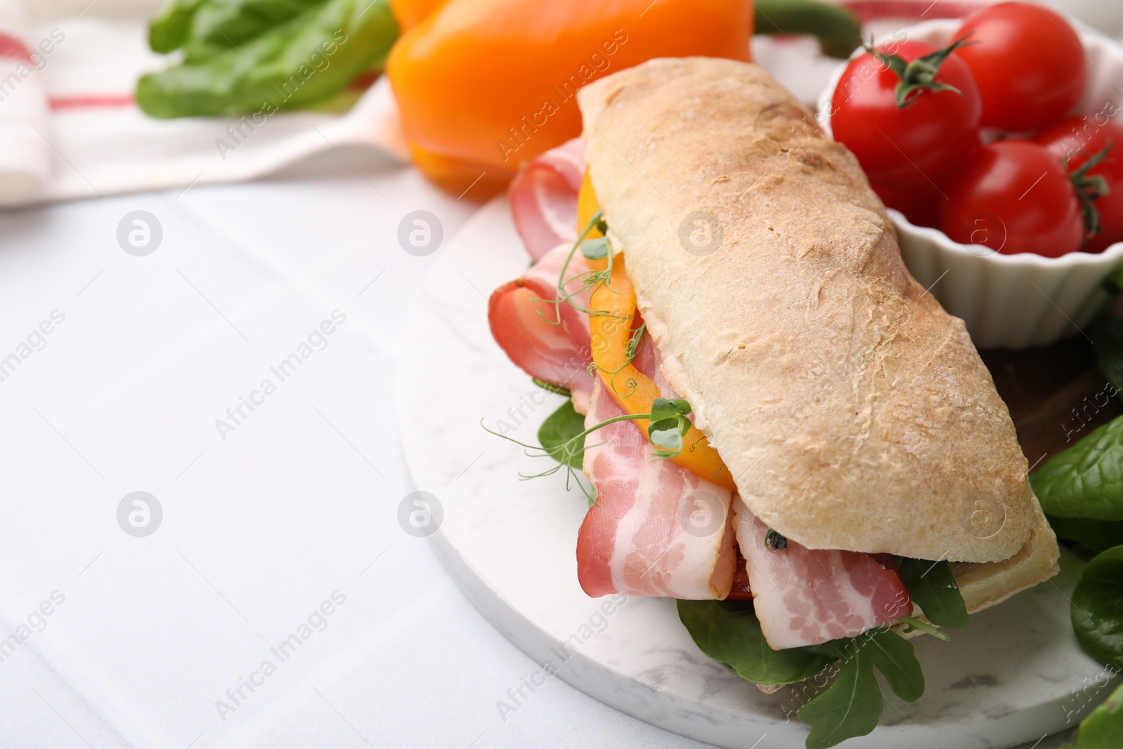 Photo of Tasty sandwich with bacon and bell pepper on white table, closeup. Space for text