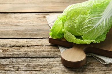 Photo of Fresh ripe Chinese cabbage on wooden table, closeup. Space for text