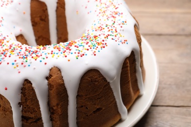 Glazed Easter cake with sprinkles on wooden table, closeup