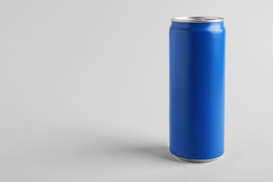 Photo of Energy drink in blue can on light grey background, space for text
