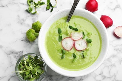 Photo of Flat lay composition with bowl of broccoli cream soup on white marble table