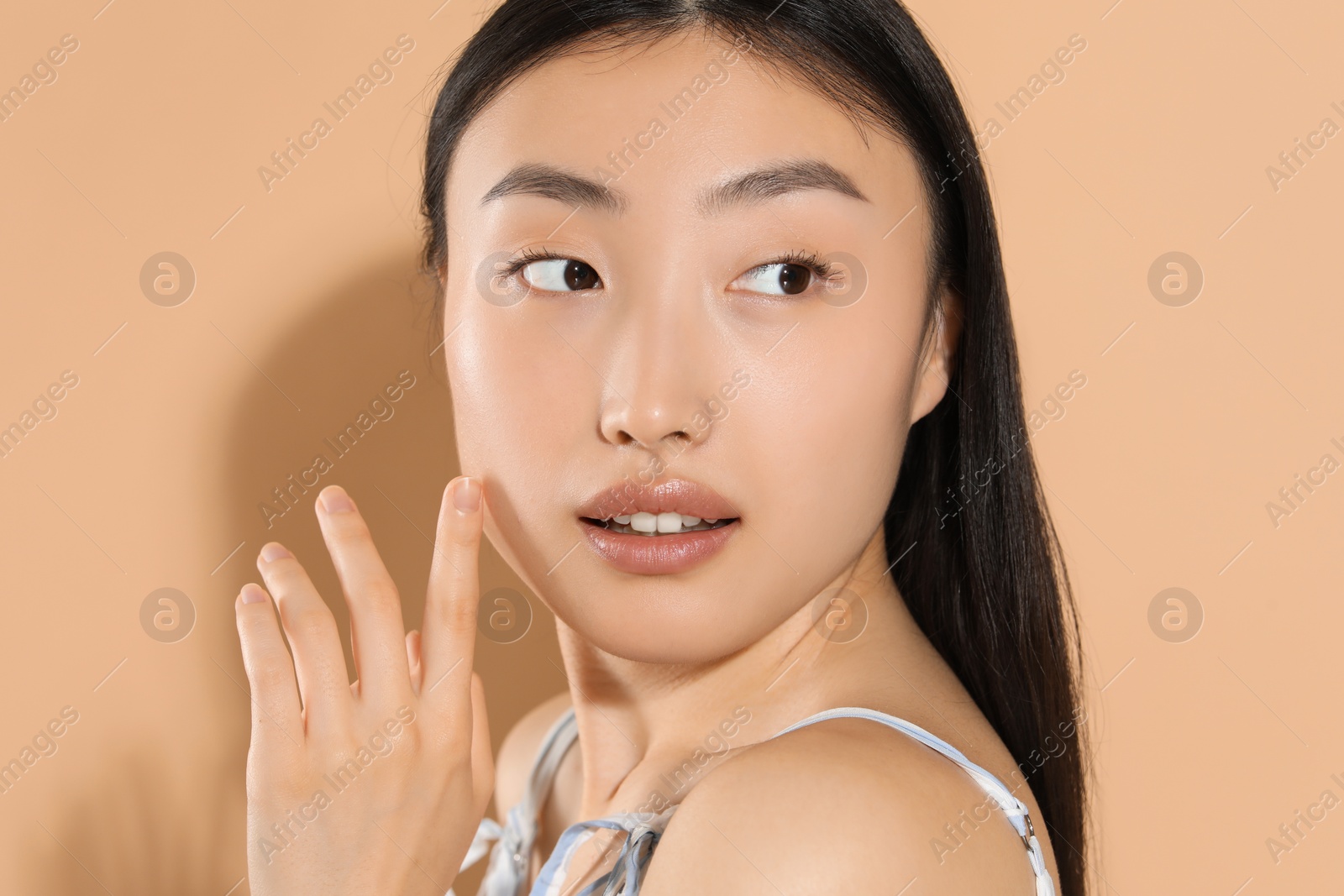 Photo of Beautiful young woman with makeup on beige background