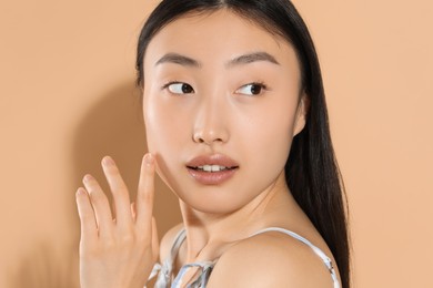 Beautiful young woman with makeup on beige background