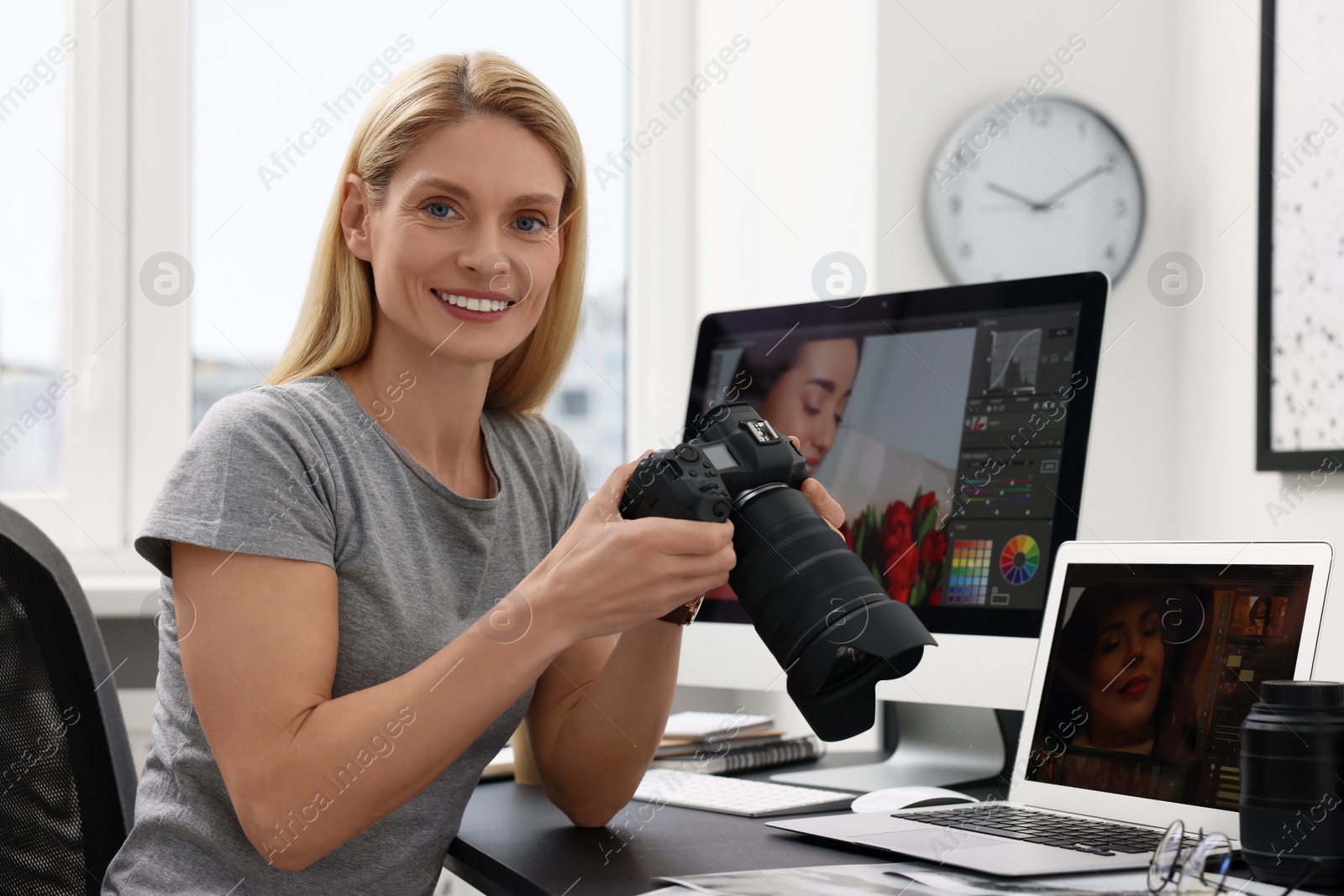 Photo of Professional photographer with digital camera at table in office