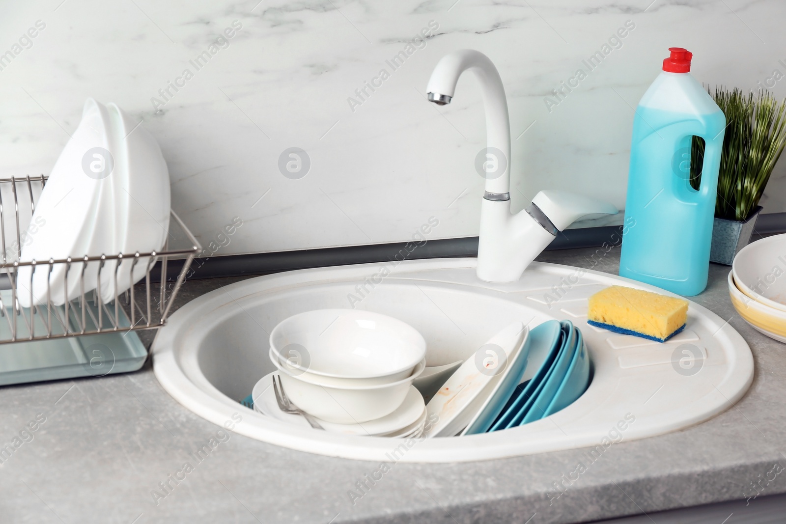 Photo of Messy pile of dirty dishes in sink