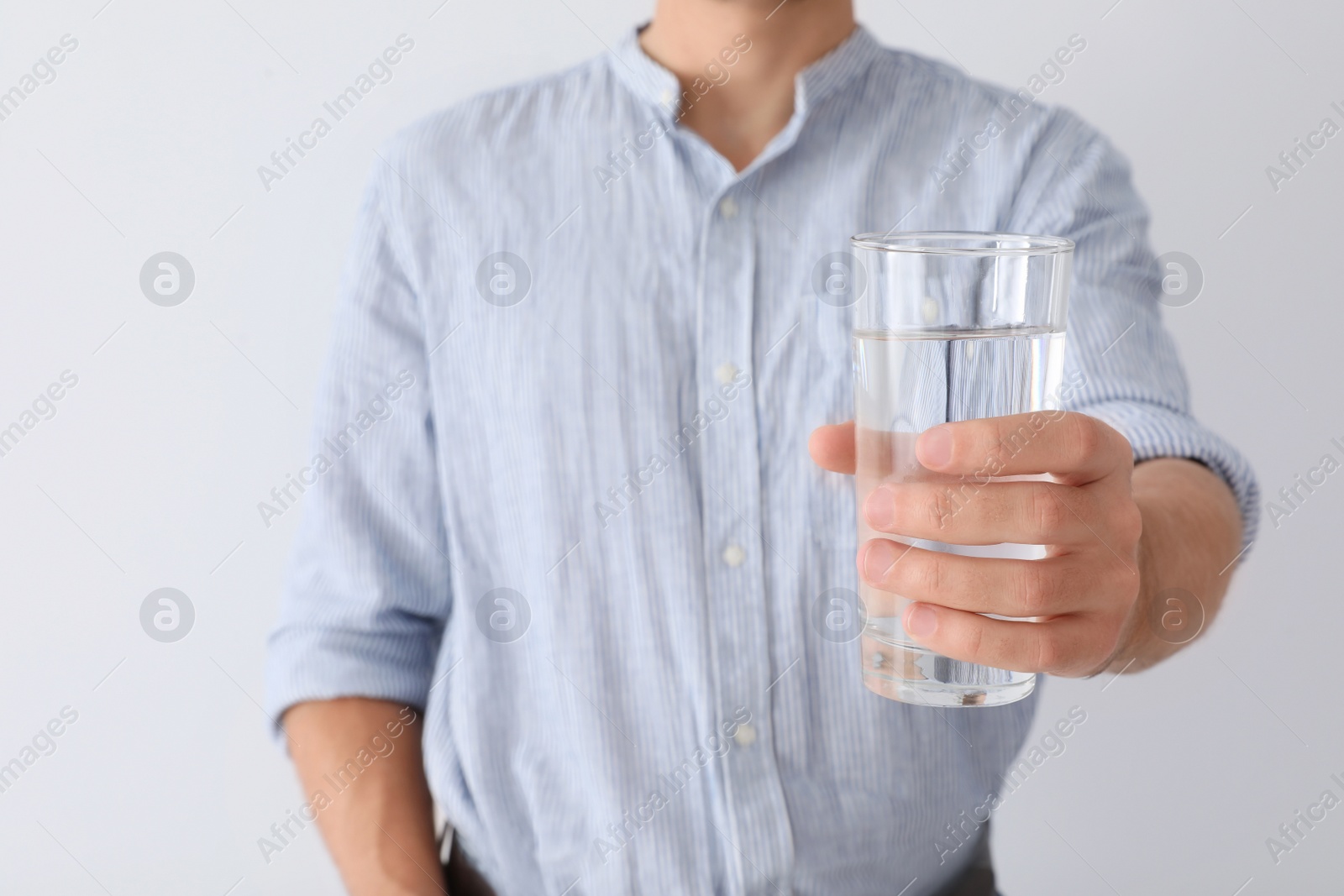 Photo of Man holding glass of pure water on white background, closeup