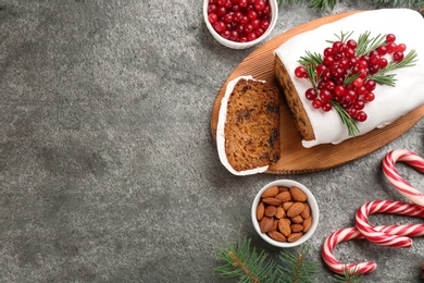 Traditional Christmas cake and ingredients on grey table, flat lay with space for text. Classic recipe