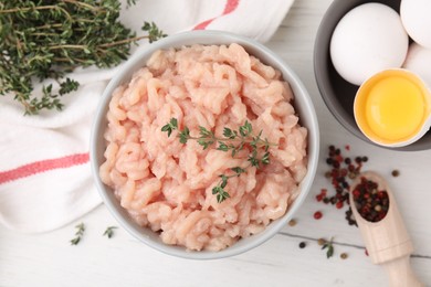 Flat lay composition with fresh raw minced meat and thyme on white wooden table