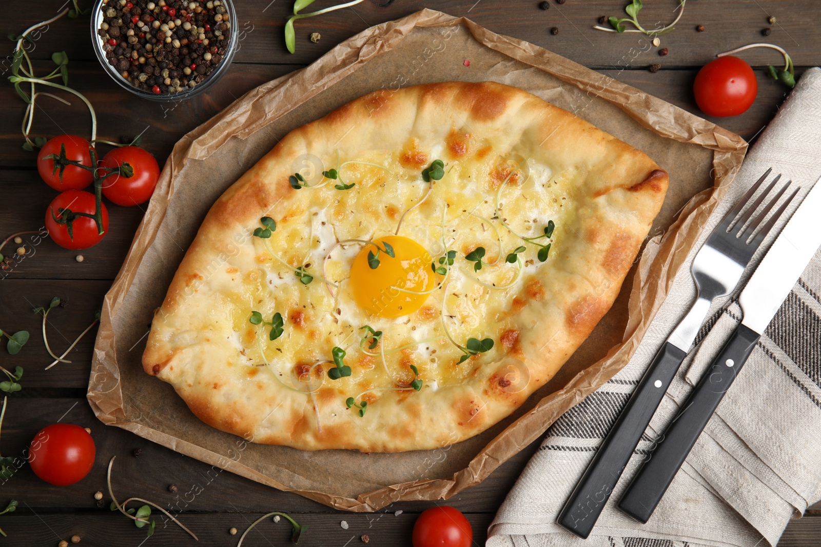 Photo of Fresh delicious Adjarian khachapuri served on wooden table, flat lay