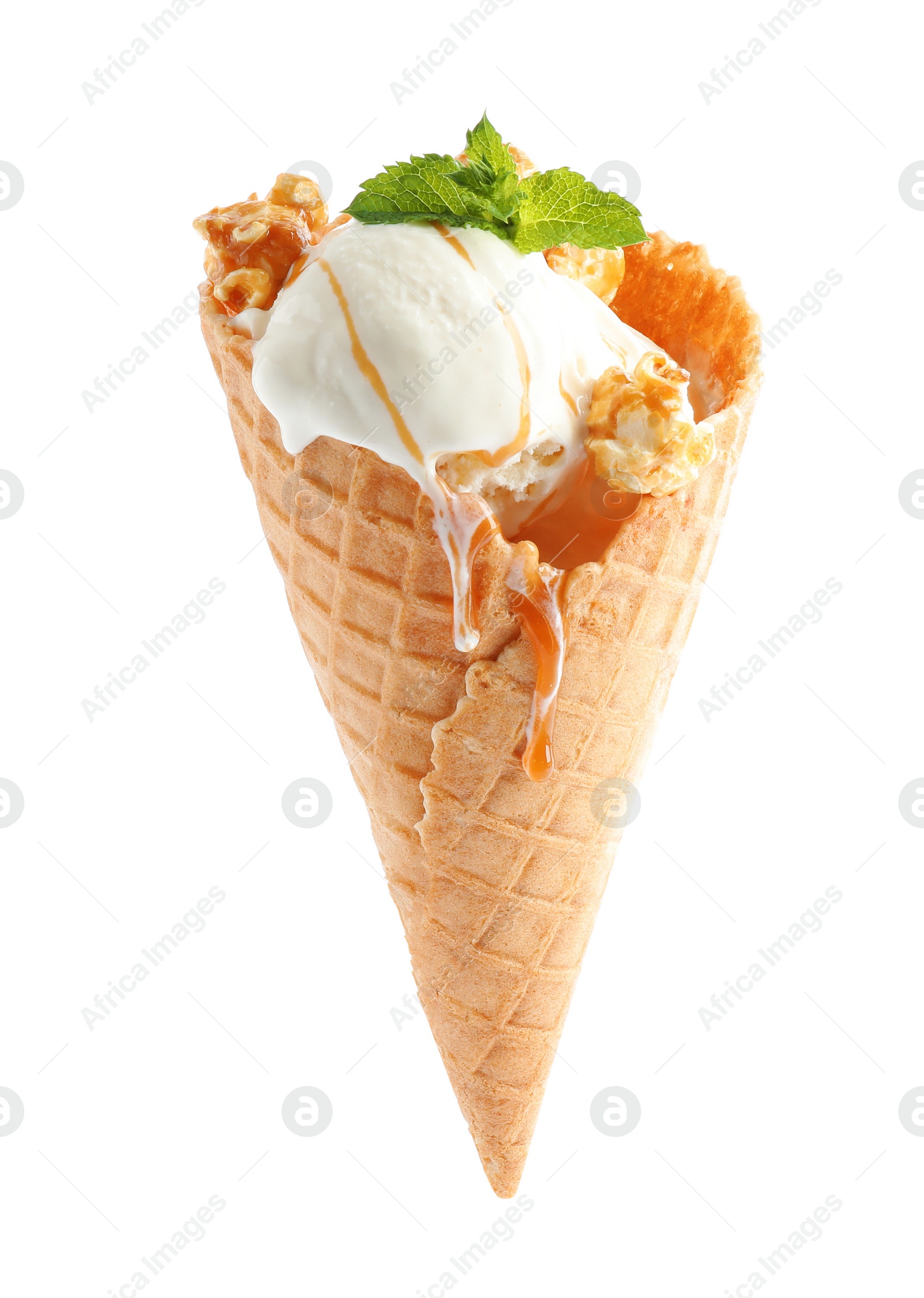 Photo of Delicious ice cream with caramel sauce, mint and popcorn in waffle cone on white background