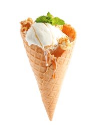 Delicious ice cream with caramel sauce, mint and popcorn in waffle cone on white background