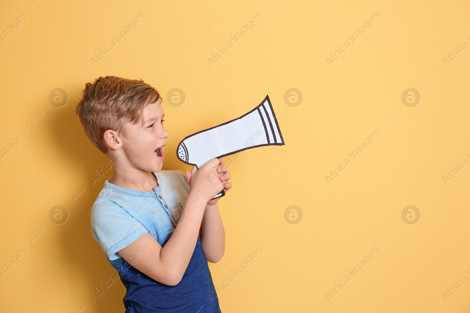 Photo of Cute little boy with paper megaphone on color background