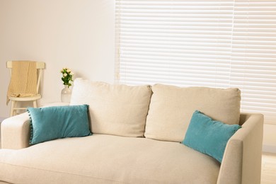 Photo of Comfortable sofa with soft pillows in light room