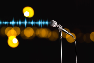Image of Microphone and radio wave on dark background, bokeh effect