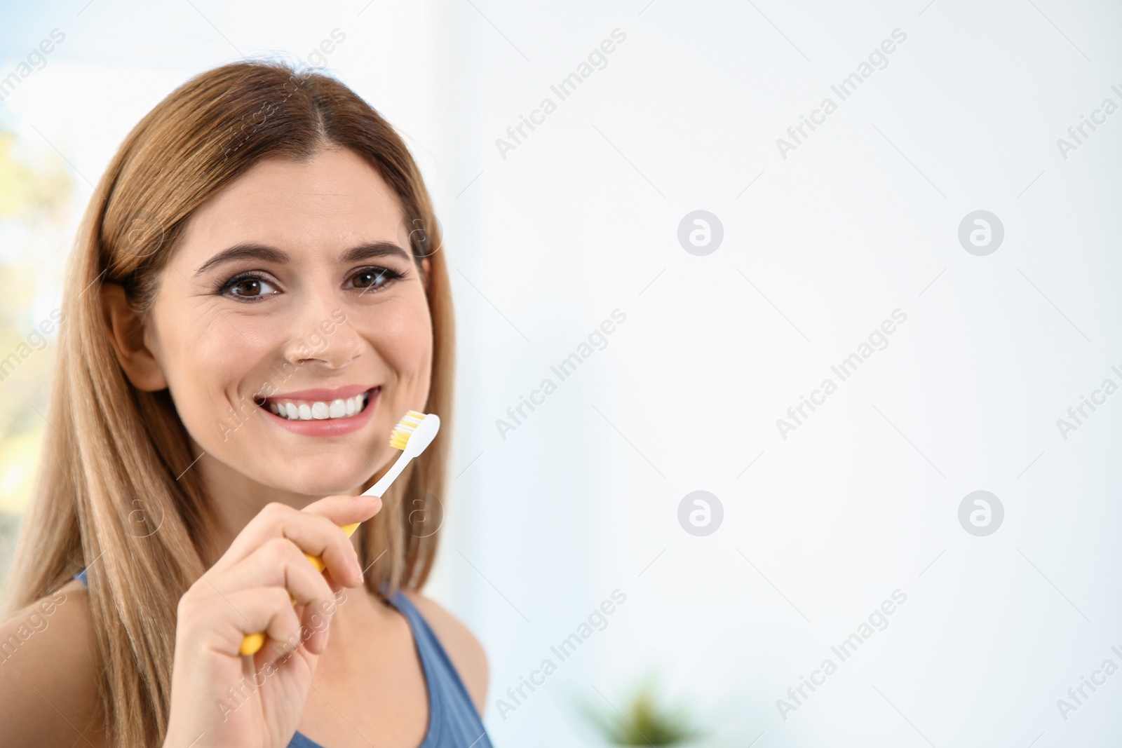 Photo of Portrait of woman with toothbrush on blurred background, space for text. Personal hygiene