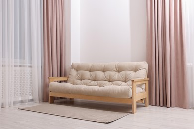 Photo of Comfortable sofa with rug in cozy light room. Interior design