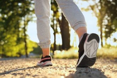 Photo of Woman running on pathway outdoors in morning, closeup