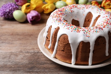 Glazed Easter cake with sprinkles on wooden table, closeup. Space for text