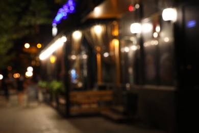 Photo of Blurred view of modern cafe with outdoor terrace at night