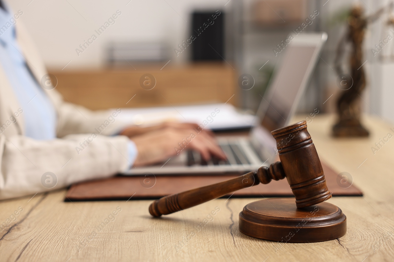 Photo of Notary using laptop at workplace in office, focus on mallet