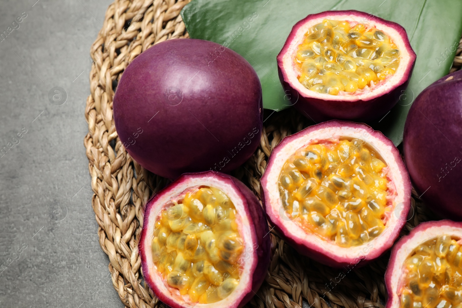 Photo of Passion fruits (maracuyas) and green leaf on grey table