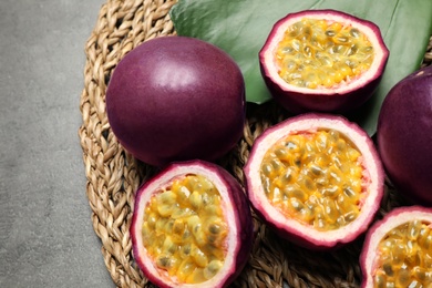 Passion fruits (maracuyas) and green leaf on grey table