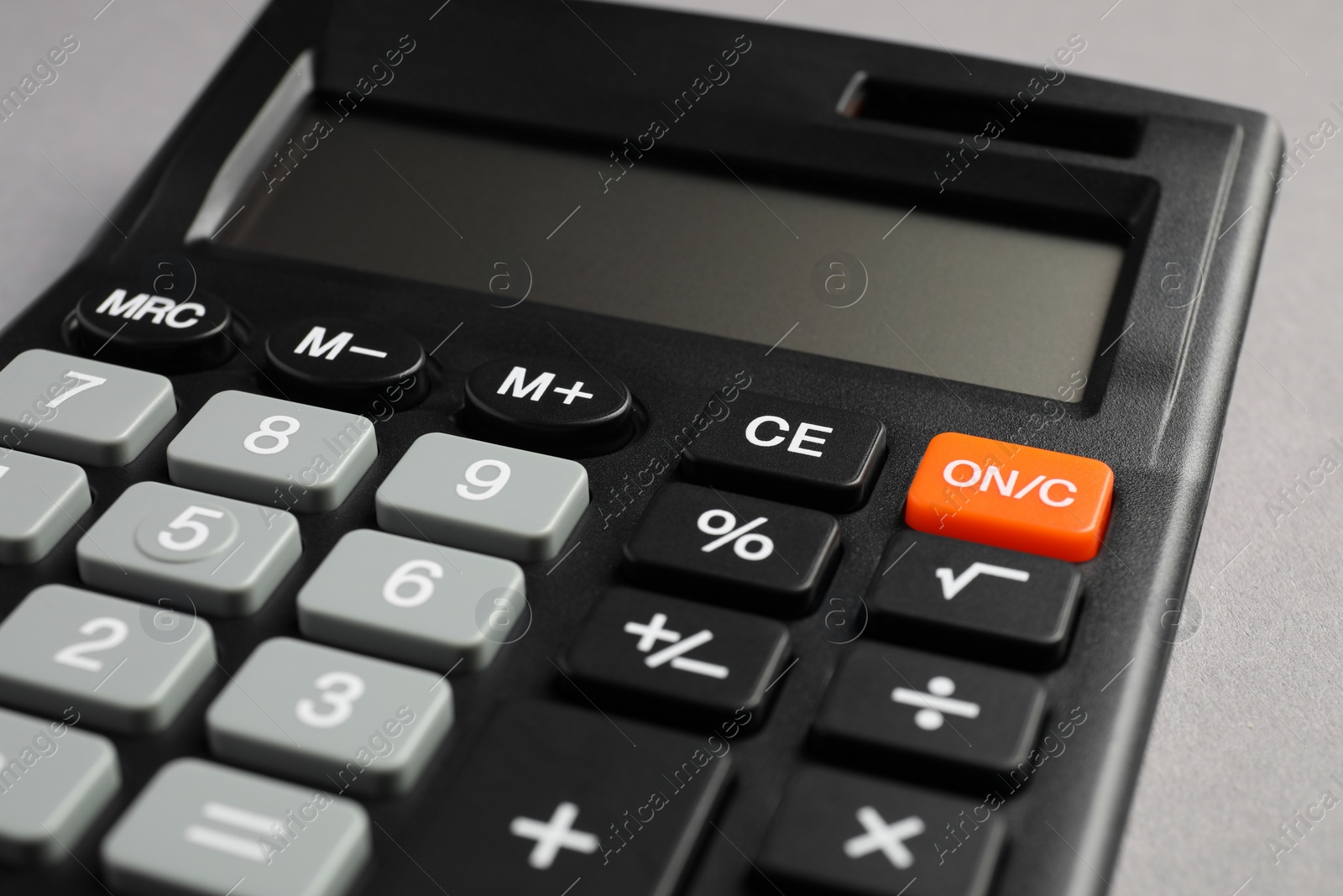 Photo of Calculator on grey background, closeup. Office stationery