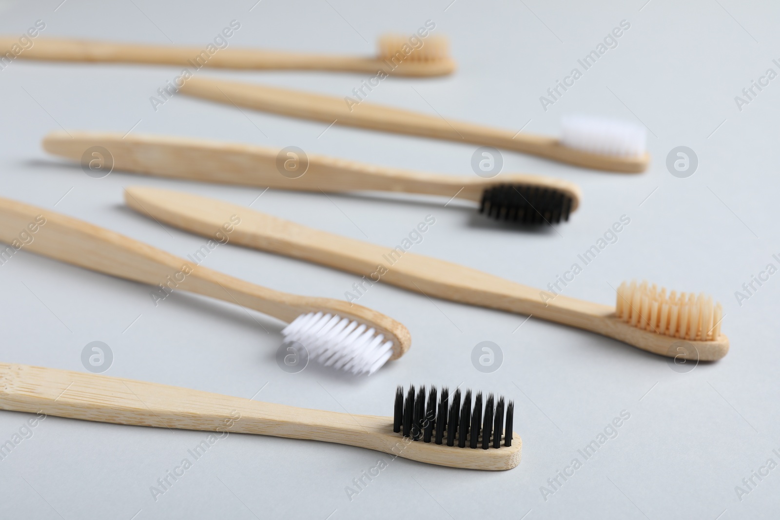 Photo of Many different bamboo toothbrushes on white background