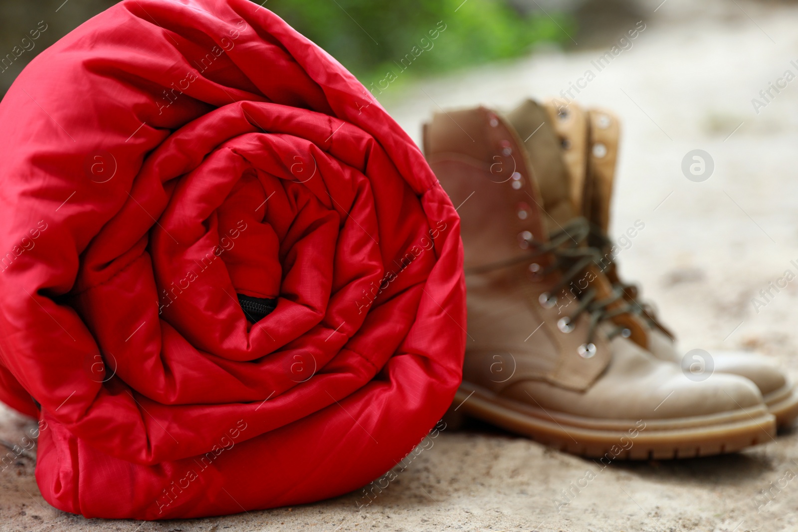 Photo of Rolled sleeping bag and boots on beach