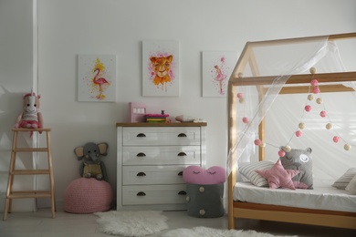 Photo of Cute pictures and and stylish furniture in baby room interior