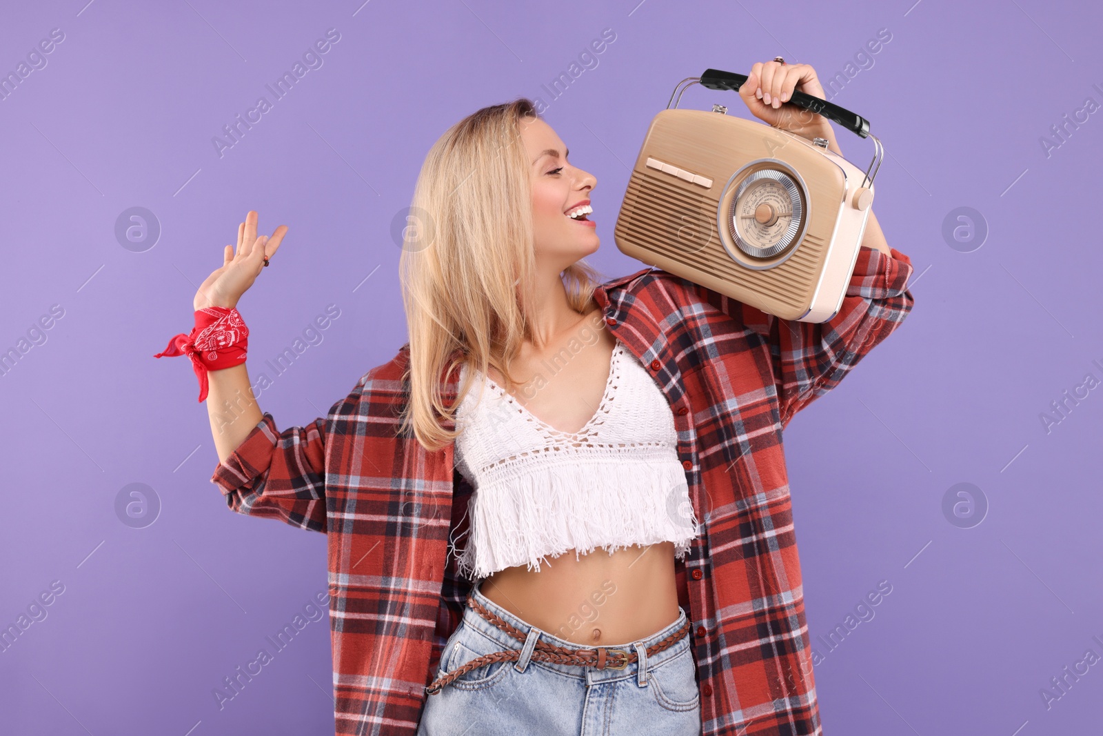 Photo of Happy hippie woman with retro radio receiver on purple background